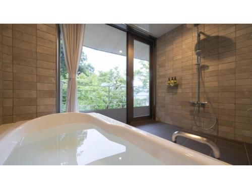 a bath tub in a bathroom with a shower at Hotel Sekisuien - Vacation STAY 44700v in Gujo
