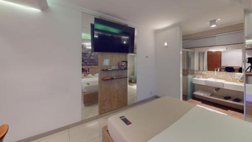 a living room with a flat screen tv on a wall at Motel DUBAI BH in Belo Horizonte