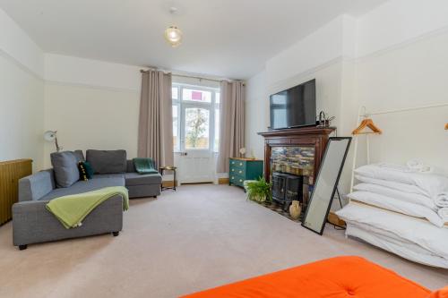 a living room with a couch and a tv at Felicity's House with Hot Tub! in Queniborough