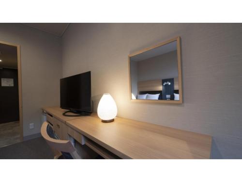 a room with a desk with a television and a lamp at Hotel Sekisuien - Vacation STAY 44651v in Gujo