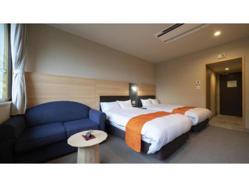 a hotel room with two beds and a blue couch at Hotel Sekisuien - Vacation STAY 44651v in Gujo