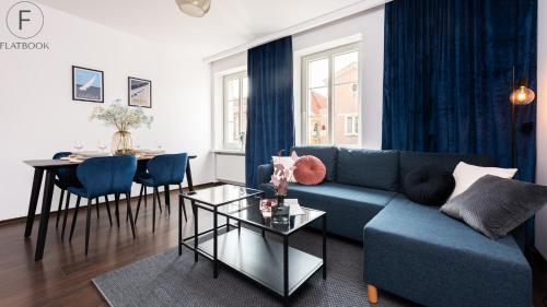 a living room with a blue couch and a table at Flatbook - In the Heart of Old Town Apartments Sw Ducha in Gdańsk