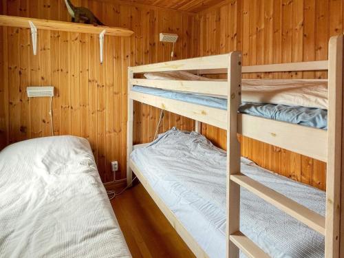 a bedroom with two bunk beds in a cabin at Holiday home ÅSTOL 