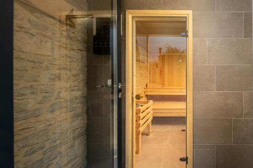 a bathroom with a shower and a glass door at Villa La Vinella with heated pool in Buje