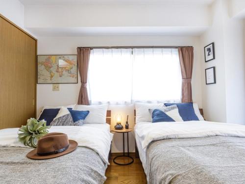 a bedroom with two beds with a hat on top of them at AirStay Horikiri 402 - Vacation STAY 45433v in Tokyo