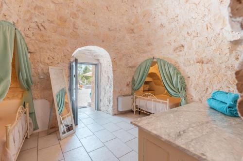 uma cozinha com uma porta para um quarto com duas camas em Trulli Olea with Pool em San Vito dei Normanni