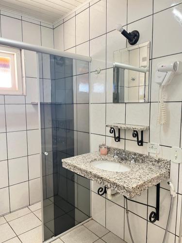 a bathroom with a sink and a mirror at Pousada do Vento in Campos do Jordão