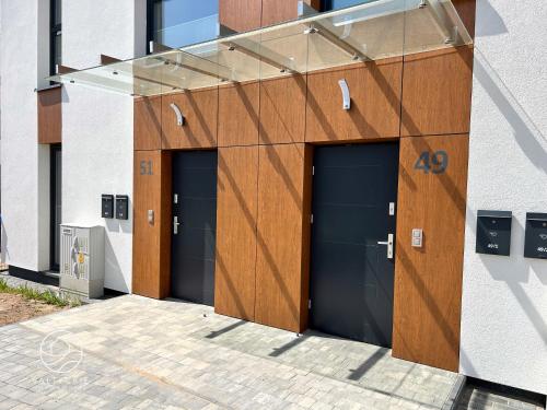 a group of four garage doors on a building at Apartamenty Bałtyckie - Luxoro Park in Ustka