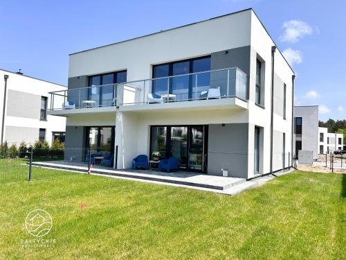 a large white house with a lawn in front of it at Apartamenty Bałtyckie - Luxoro Park in Ustka