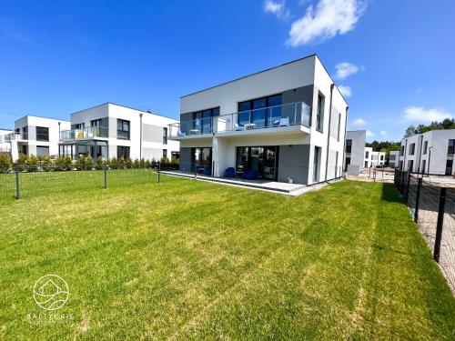 a large white house with a large yard at Apartamenty Bałtyckie - Luxoro Park in Ustka