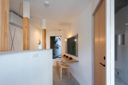 a kitchen with white walls and a table and chairs at Ryokan Nishijin - Vacation STAY 46289v in Kyoto