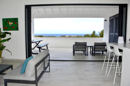 a living room with a table and chairs and a large mirror at Blue Bay Penthouse REEF 5, BEACH GOLF POOL DIVE with OCEAN View in Sint Michiel