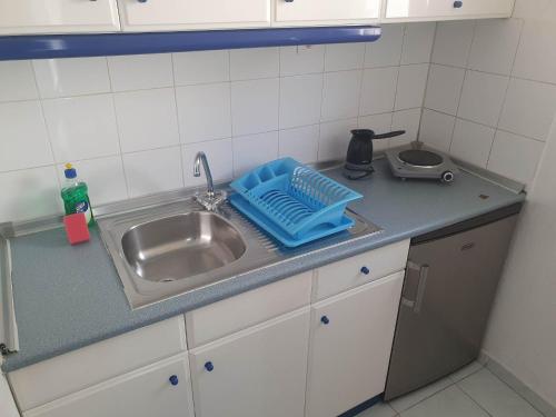 帕拉塔蒙Toula's Apartments的厨房水槽和蓝色的盘子旁边