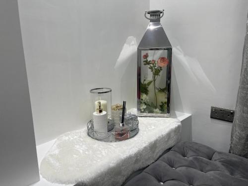 een kamer met een tafel met een vaas van bloemen en kaarsen bij Luxury Holiday Home in Manchester