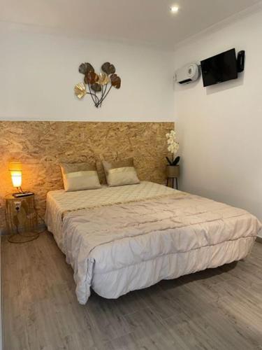 a bedroom with a large bed with a speaker at Casa Pejão Do Paraíso in Castelo de Paiva
