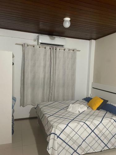 a bedroom with a bed and a window with at Central 2 - Pousada in Uruguaiana