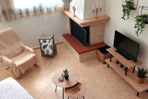 sala de estar con sofá y chimenea en Nostos House en Néa Ankhíalos
