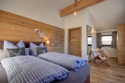 a bedroom with a bed with blue and white pillows at Chalet Charivari Inzell mit Whirlpool, Sauna & Garten in Inzell