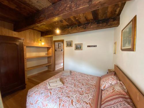 a bedroom with a bed in a room with wooden ceilings at L'Oasi di Sodani1 in Sampeyre