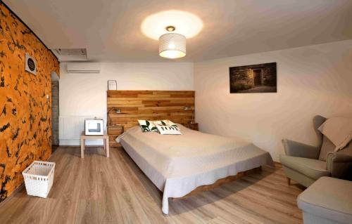 a bedroom with a bed and a couch and a chair at Szent György Kúria in Kisharsány
