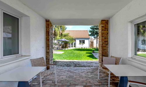 a patio with tables and chairs and a yard at Szent György Kúria in Kisharsány