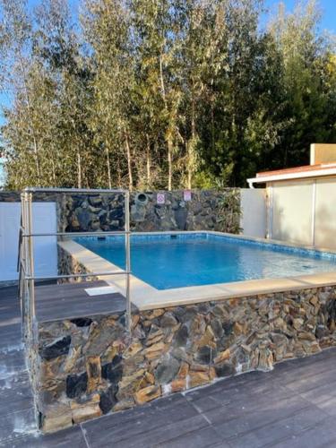 a swimming pool with a stone wall next to anergynergynergynergyploadpload at Casa Pejão Do Paraíso in Castelo de Paiva