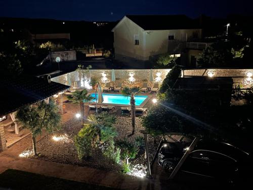 una vista aérea de una piscina por la noche en Guest House Antonella en Malinska