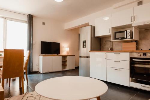 une cuisine avec des armoires blanches et une table blanche dans l'établissement Calvi. T2 2/4 personnes à 100 mètres de la plage, à Calvi