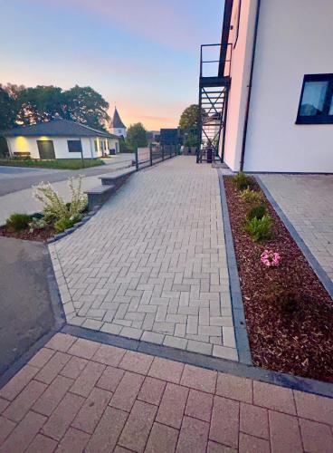 a brick sidewalk next to a building with a staircase at Gästehaus Veenstra in Kelberg