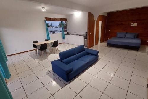 a living room with a blue couch and a table at Moorea Maharepa Appartement in Paraoro