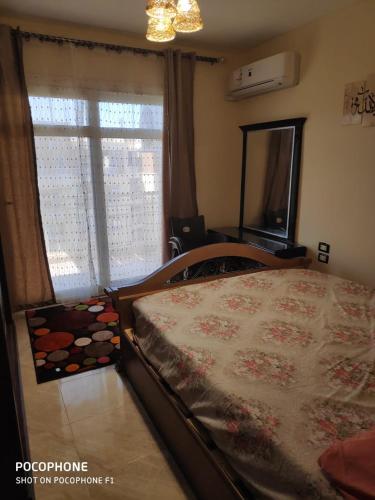 a bedroom with a bed and a large window at مدينتي in Madinaty