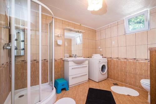 a bathroom with a shower sink and a washing machine at Vacation house Anna in Karlobag