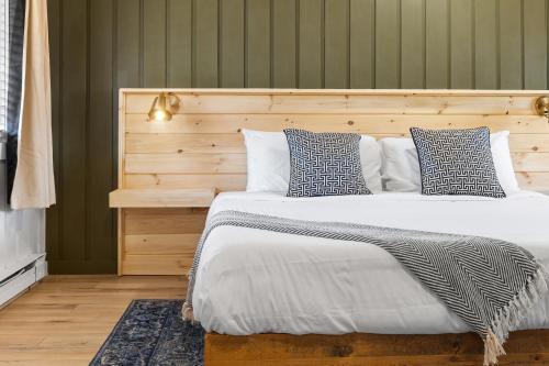 a bedroom with a large bed with a wooden headboard at The Boha Hotel in Lake Placid