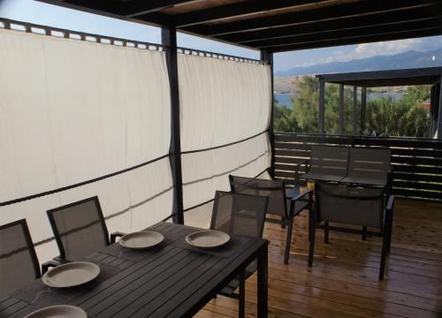 un patio con mesa y sillas en una terraza en Sweet Dreams mobile home, Terra Park SpiritoS en Kolan