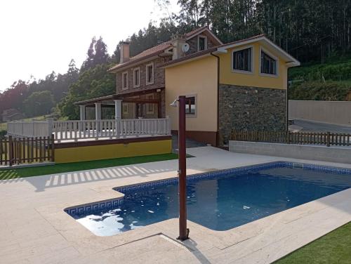 uma casa com piscina em frente a uma casa em Casa rural con piscina, Cedeira, San Román em Cedeira