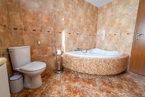 a bathroom with a toilet and a bath tub at Mia's House in Mikołajki