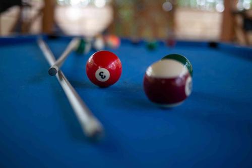 dos bolas de billar en una mesa de billar azul en Lakepoint Cottage Resort en Killaloe Station