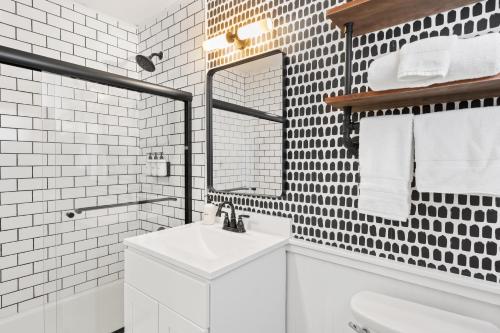 La salle de bains blanche est pourvue d'un lavabo et d'un miroir. dans l'établissement The Boha Hotel, à Lake Placid