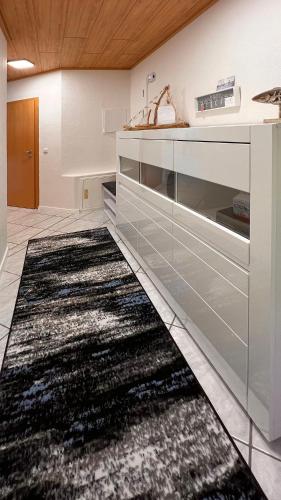 a kitchen with a black and white rug on the floor at Ferienwohnung am Sonnenstrahl in Dorum Neufeld