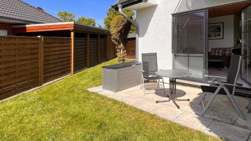 a backyard with a grill and a table in the grass at Ferienwohnung am Sonnenstrahl in Dorum Neufeld