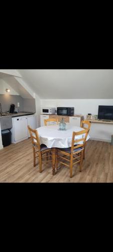 une salle à manger avec une table et des chaises dans une cuisine dans l'établissement appartement proche gerardmer, à Granges-sur-Vologne