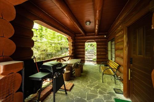 a porch of a log cabin with a stove at ログハウスGrazzi in Nasu-yumoto