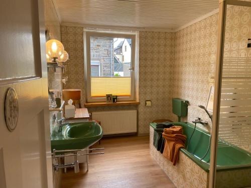 a bathroom with a green sink and a tub at Stück vom Glück in Enkirch