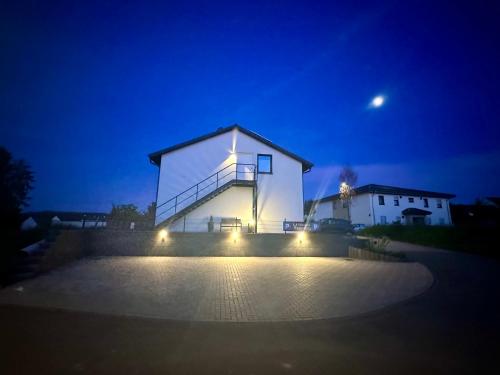 a white house at night with lights on it at Gästehaus Veenstra in Kelberg