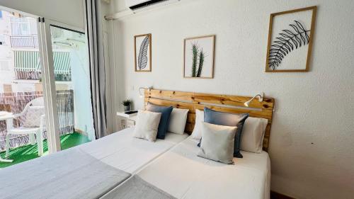 - une chambre dotée d'un grand lit avec des draps et des oreillers blancs dans l'établissement Estudio Brisa en el centro de Nerja - South Costa, à Nerja