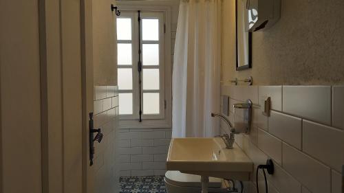 een badkamer met een wastafel en een raam bij Nil House Ayvalık in Ayvalık