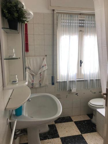 une salle de bain blanche avec un lavabo et des toilettes dans l'établissement villa stella del mare, à Acireale