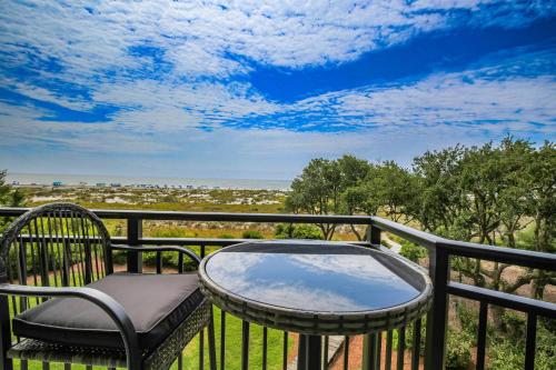 a table and chair on a balcony with a view at Ocean Therapy in Isle of Palms