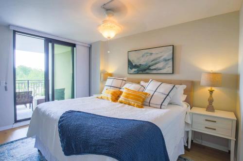 a bedroom with a bed with yellow and blue pillows at Ocean Therapy in Isle of Palms