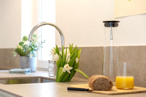 - un comptoir de cuisine avec un pain et un verre de jus d'orange dans l'établissement Massaresc apartment, à Cugnasco